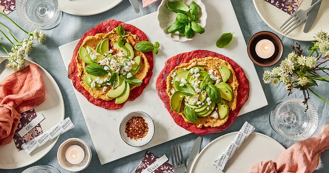 Pizza alle barbabietole con pomodori secchi, hummus e avocado