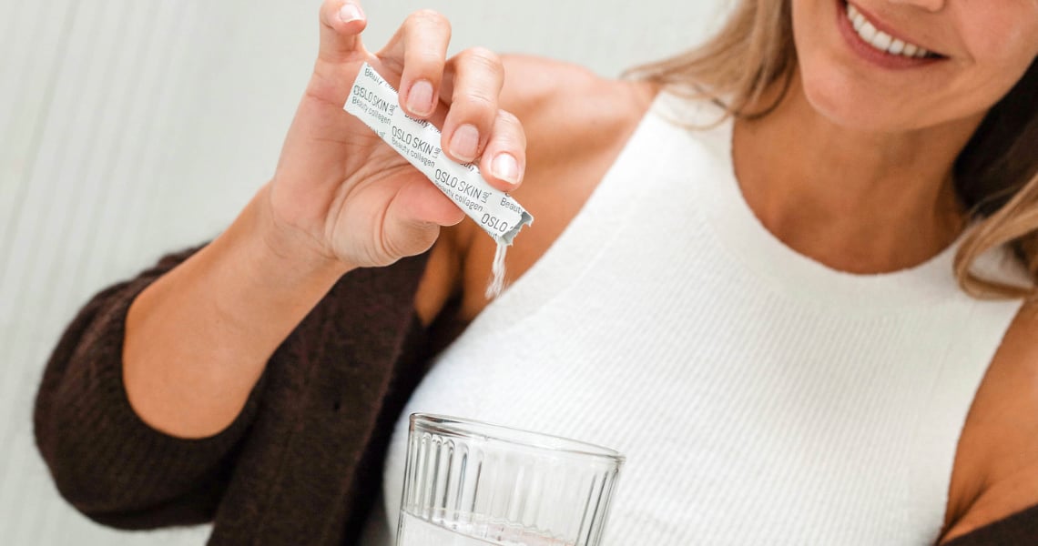 Closeup di donna che versa bustina di The Solution in un bicchiere