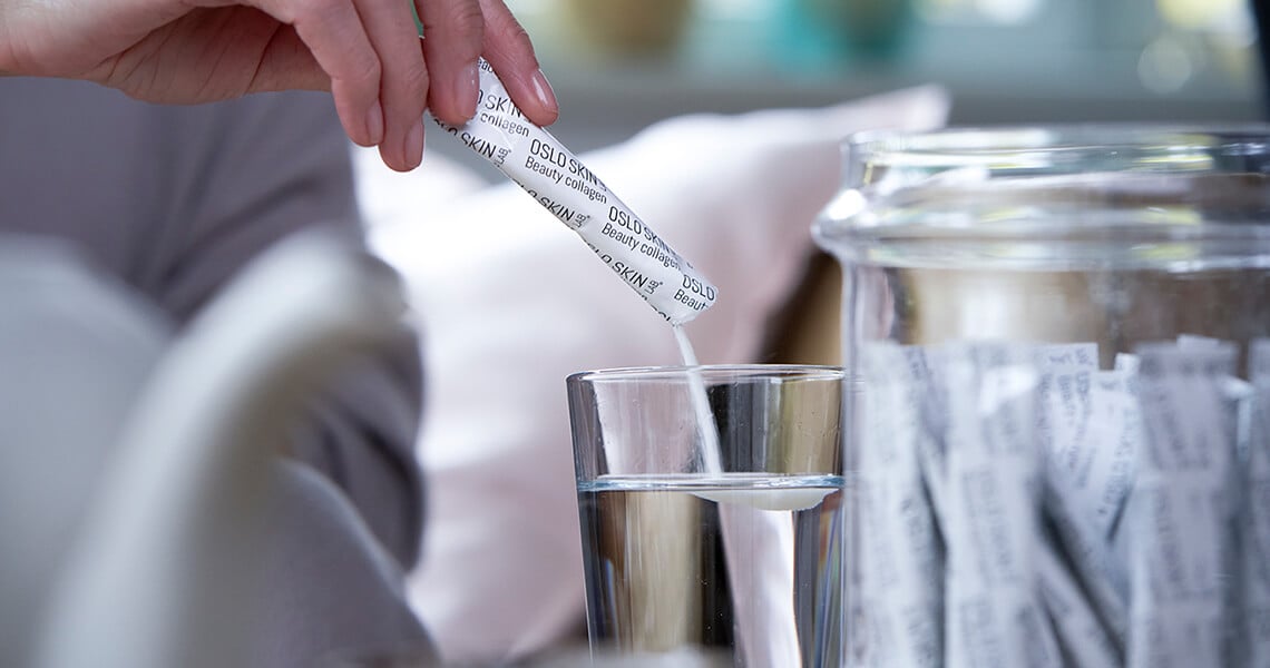 Mano che versa una bustina The Solution in un bicchiere d'acqua